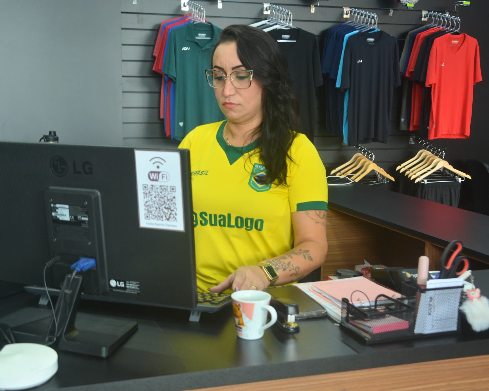 Funcionária usando camisa Brasil no atendimento Copa 2026 - Uniforme corporativo Icone Sports